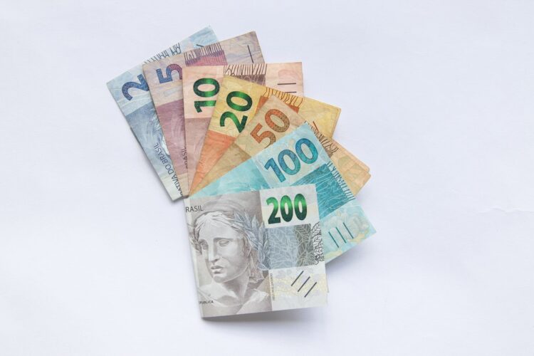Cédulas de real brasileiro em leque sobre fundo branco