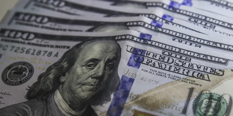 Cédulas de dólar e moedas de real, símbolo da variação cambial