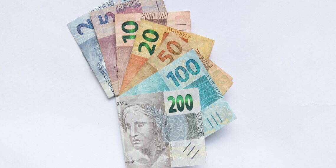 Cédulas de dinheiro brasileiro (real) dispostas em leque sobre fundo branco